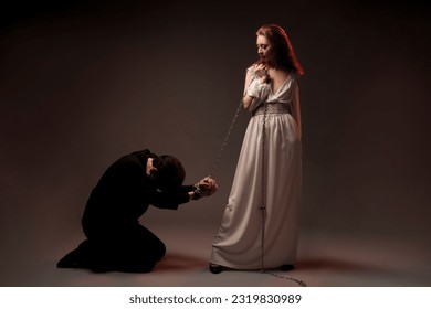 Man with tied hands kneeling near woman