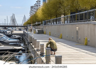 A man ties the boat to the pier. Parking for boats and yachts.  - Powered by Shutterstock