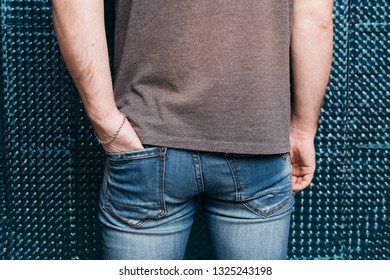 Man In Tight Jeans. Sports Ass Close-up. Street Style Clothing: Spring Skinny Jeans And A Gray T-shirt. Men's Health: The Pain Caused By Hemorrhoid