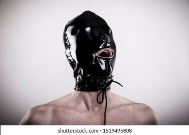 man with tight latex mask hood looking up to his dominatrix with open mouth