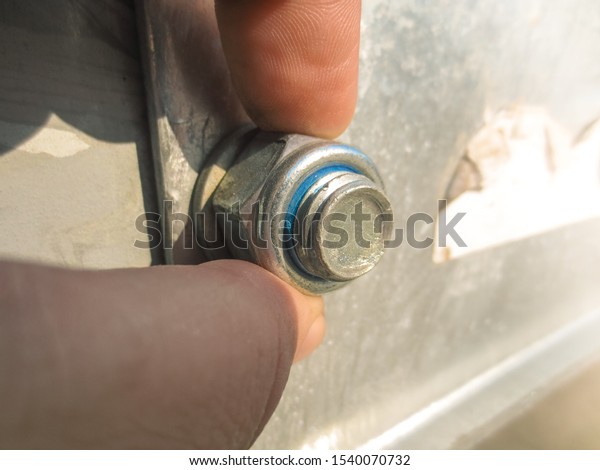 The man tightens the nut by hand. Worker tightens\
the nut with his fingers