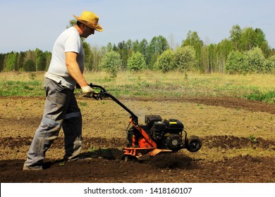 A Man Tilling Ground With Motor-cultivator