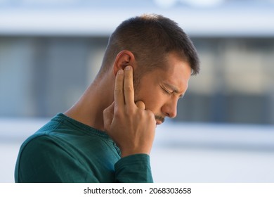 Hombre con acúfenos. Hombre tocando su oído por fuerte dolor de oído o de oído. Otitis