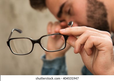 Man with tired eyes after long work holding his eyeglasses - Powered by Shutterstock