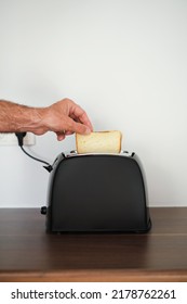 Man Toasting Bread In A Toaster