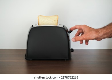 Man Toasting Bread In A Toaster