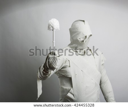 Man in toilet paper with toiletbrush