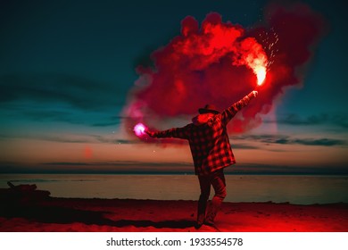 Man with torch fire in hands goes at sunset lake beach - Powered by Shutterstock