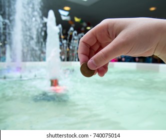 A Man Tosses A Coin Into A Fountain