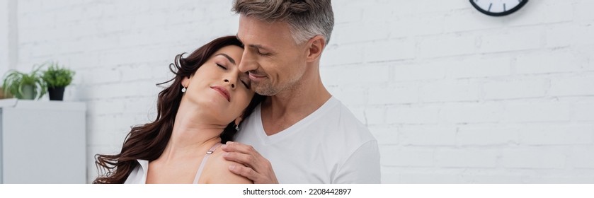 Man Touching Brunette Wife In Kitchen At Home, Banner