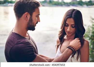 Man Is Touching Her Hair By The Water. Evening Love Scene