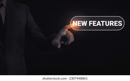 Man touching new features concept typography with glowing light and dark backdrop. Technology new features concept background - Shutterstock ID 2307448861