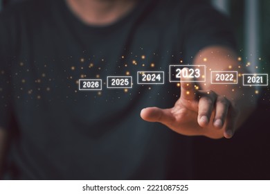 A man touching on virtual screen 2023. Business new year concept, welcome to year 2023 concept.