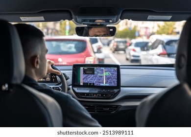 Man touching screen of a GPS navigation system in his car.