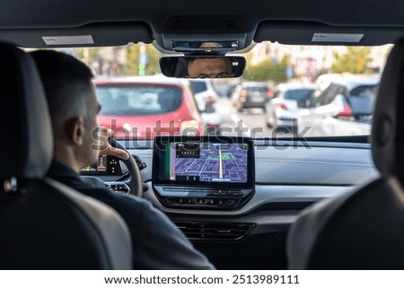 Man touching screen of a GPS navigation system in his car.