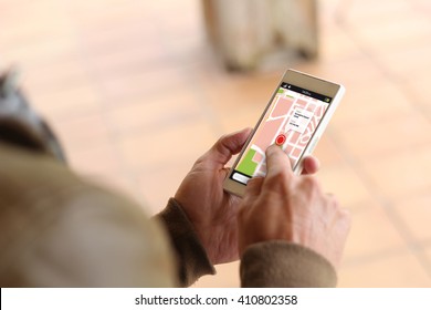 man touching the screen of his smartphone showing gps app. All screen graphics are made up.