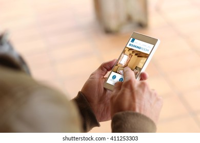 Man Touching The Screen Of His Smartphone At Street To Hotel Reservation. All Screen Graphics Are Made Up.