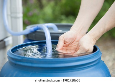 man touching water of rain tank