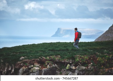 Man tourist walks on Stunning Latrabjarg cliffs, Europe's largest bird cliff and home to millions of birds, including puffins, northern gannets, guillemots and razorbills. Western Fjords of Iceland