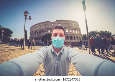 Mann touristische Maske im Kolosseum in Rom fotografieren und mit Smartphone während Coronavirus COVID-19 Weltherausbruch Konzept. Tourist, der eine Schutzmaske für die Sanitäranlagen hält