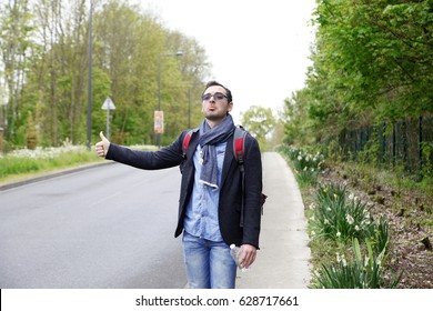 Man tourists hitchhiking along a road