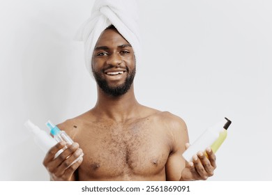 Man with towel on head holding shampoo and conditioner bottles, deciding on hair care products in bathroom - Powered by Shutterstock