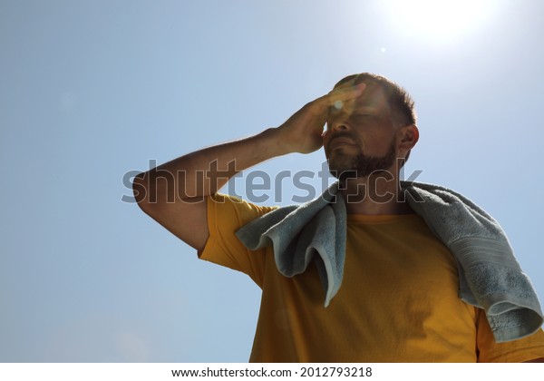 Man with\
towel suffering from heat stroke\
outdoors