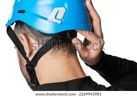 Man, tower worker. Work at height. Tourist, climber. Dressing and adjusting a helmet, a protective helmet. Isolated on white background.