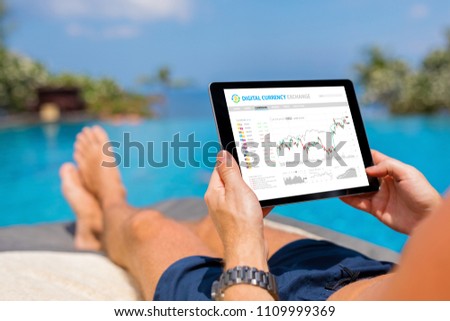 Man trading digital currencies online while relaxing by the pool.