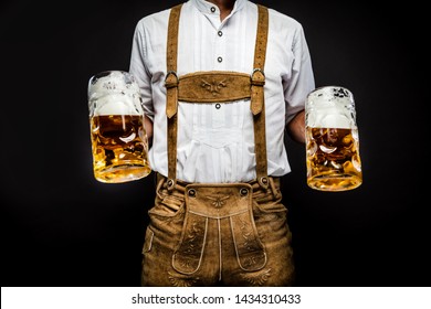 Man in traditional bavarian clothes holding mug of Oktoberfest beer