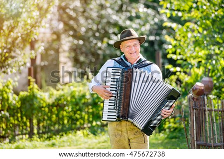 Man in traditional bavarian clothes playing the accordion