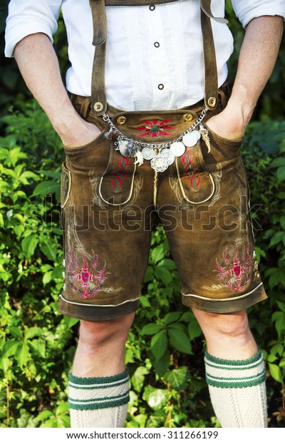 man in traditional bavarian leather pants\
standing outdoors