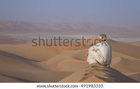 Man in traditional outfit in Empty Quarter Desert that covers a large area of UAE, KSA and Oman