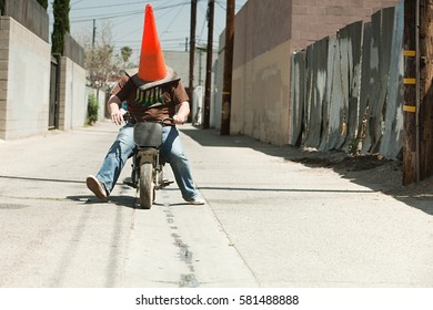 Man With Traffic Cone On Head, Riding Motorbike