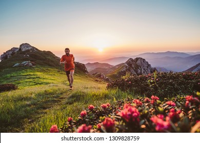 Man Trail Running On A Mountain At The Sunrise