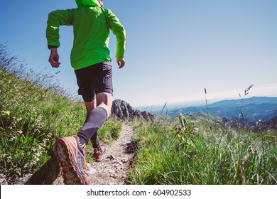 Man Trail Running On A Mountain In Summer