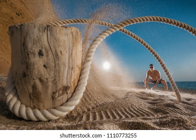 Man Training With Battle Rope On The Beach. Athlete Doing Cross Fitness Workout Outdoor. Sport Fit Exercise.