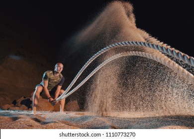 Man Training With Battle Rope On The Beach. Athlete Doing Cross Fitness Workout Outdoor. Sport Fit Exercise.