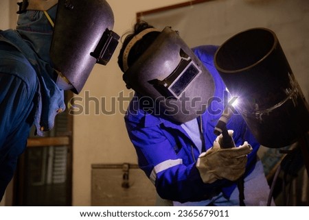 A man is training to be a welder and another person is in charge of the examination. Welder are assembling the workpiece by Tungsten Inert Gas Welding process (TIG).