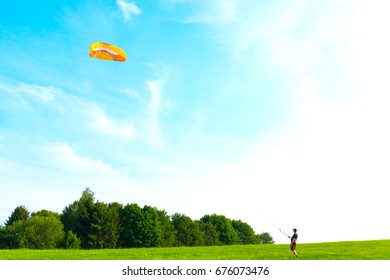 Man is training to catch wind in the field with a kite	
