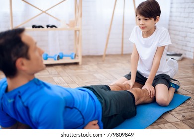 A man is training a press with the help of a boy. This is father and son. They are at home.