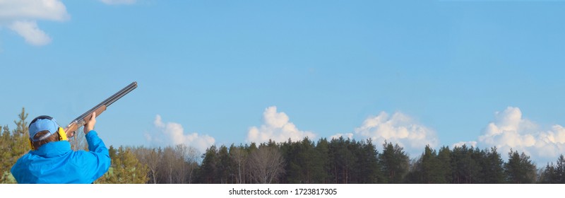 Man Trains To Shoot A Double-barreled Hunting Rifle On A Sports Stand In A Blue Sky Shooting Club, Clay Pigeon In To The Blue Sky , Copy Space