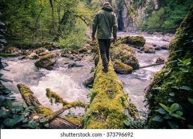 Человек-путешественник, пересекающий реку на бревенчатом стиле жизни на открытом воздухе 