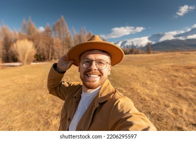 Man Traveler In Hat Making Selfie Video Vlog About Travel Mountains.