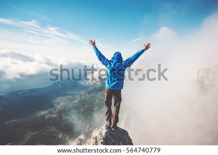 Man Traveler on mountain summit enjoying aerial view hands raised over clouds Travel Lifestyle success concept adventure active vacations outdoor happiness freedom emotions