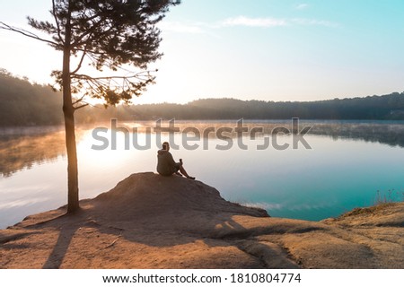Man traveler relaxing alone in mountains travel lifestyle concept bright morning nature landscape on background. Lake and mountains. inspiration concept, enjoy life.