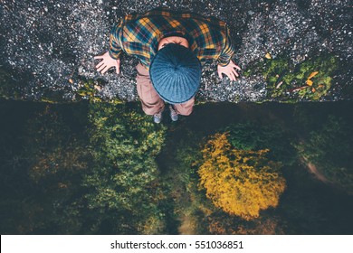 Человек путешественник сидит на краю скалы моста с видом на лес с высоты полета путешествия образ жизни приключенческий отпуск концепция