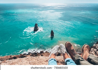 Man traveler sitting on mountain alone and looking at autumn sea landscape. Hiking in cold season. Wanderlust concept scene. Feet above coast high view. - Powered by Shutterstock