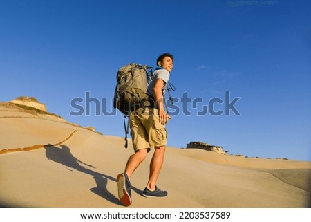 Man traveling with backpack hiking in rock Travel Lifestyle success concept adventure active vacations outdoor sport.