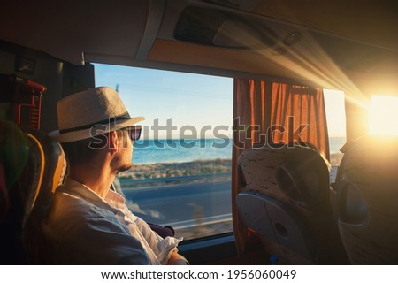 A man is traveling and looking through the bus window during the covid19 corona virus  pandemic	